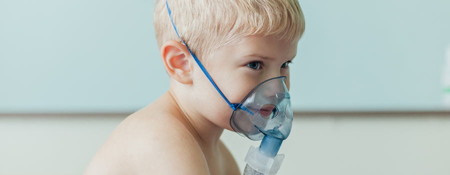 Infant baby with oxygen face mask and respiratory infection in hospital.